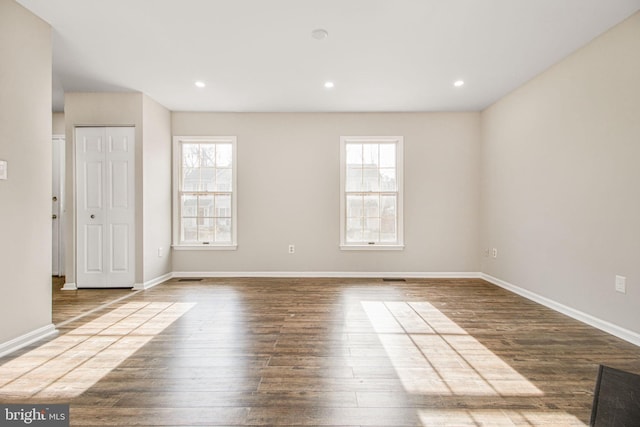 spare room with plenty of natural light and hardwood / wood-style flooring