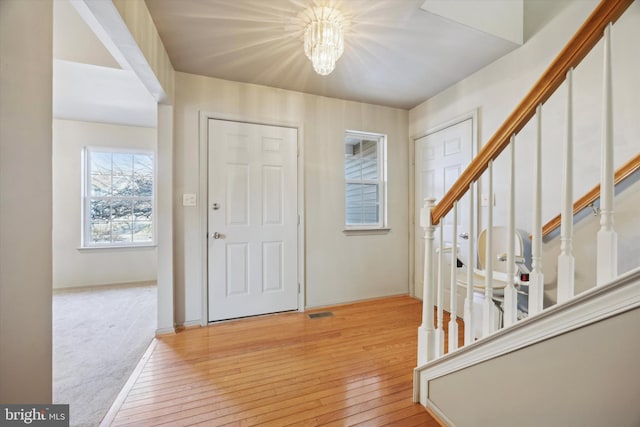 foyer with an inviting chandelier and light hardwood / wood-style flooring