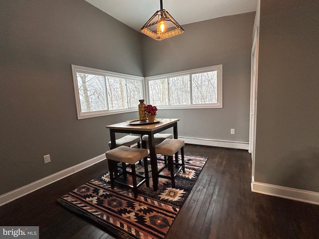 dining room with dark hardwood / wood-style flooring, vaulted ceiling, and baseboard heating