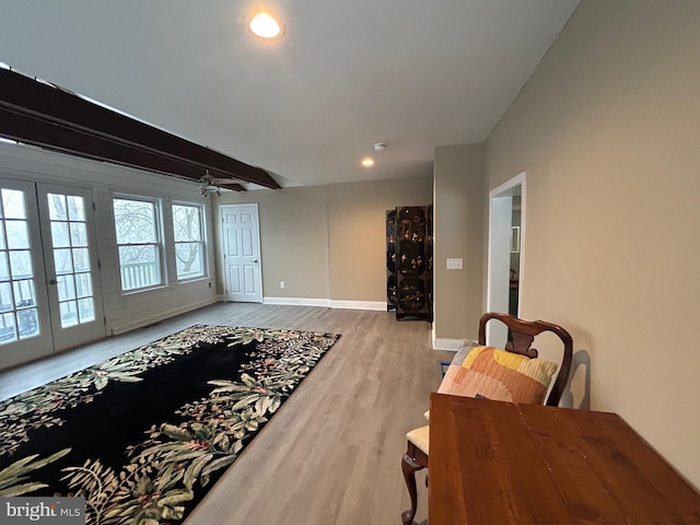 living room featuring ceiling fan, beam ceiling, and light wood-type flooring