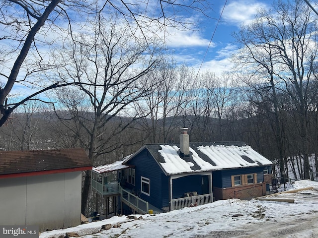 view of snow covered exterior with a balcony and covered porch