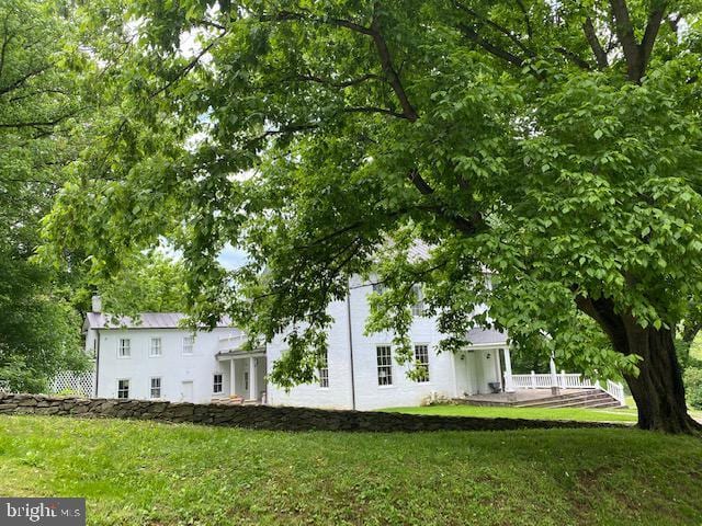 rear view of property featuring a yard