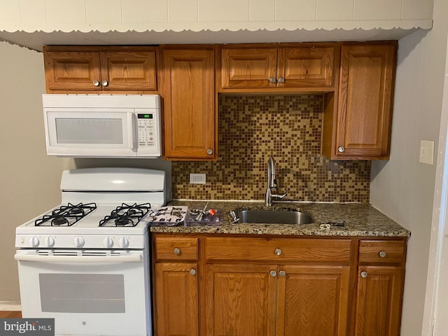 kitchen with sink, white appliances, and backsplash