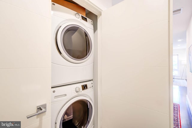 clothes washing area with stacked washer and clothes dryer