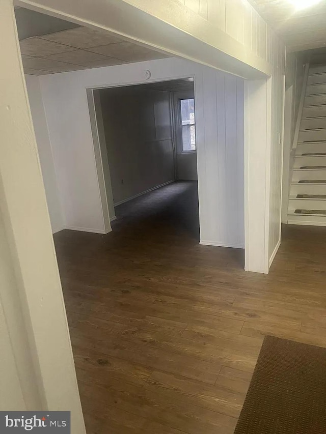 corridor with dark hardwood / wood-style flooring