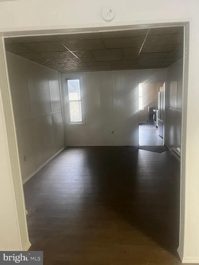 spare room with dark hardwood / wood-style floors and radiator heating unit