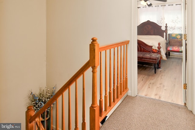 hallway with light carpet and an upstairs landing