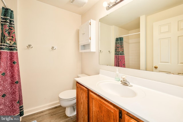 bathroom with visible vents, baseboards, toilet, wood finished floors, and vanity