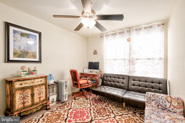 carpeted living room featuring a ceiling fan, baseboards, and radiator heating unit