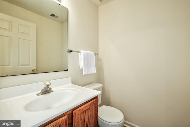 bathroom with toilet, visible vents, and vanity