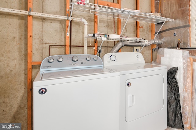 clothes washing area featuring laundry area and washer and clothes dryer