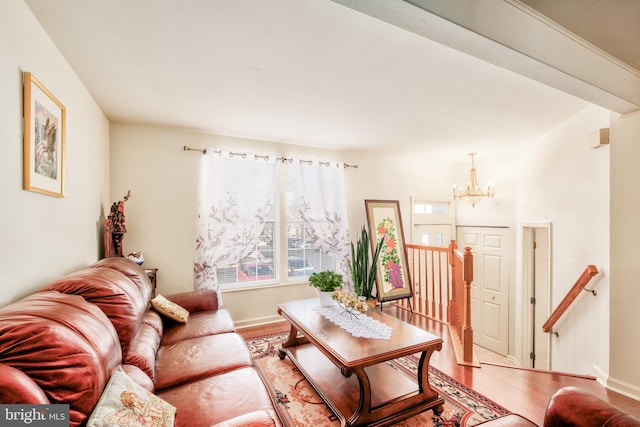 living area featuring a chandelier, wood finished floors, and baseboards