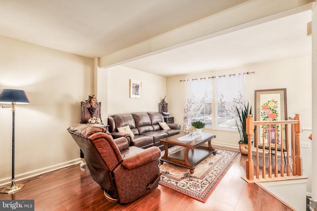 living room with beam ceiling, baseboards, and wood finished floors