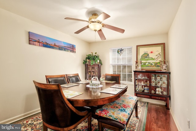 dining room featuring dark wood-type flooring, a ceiling fan, and baseboards