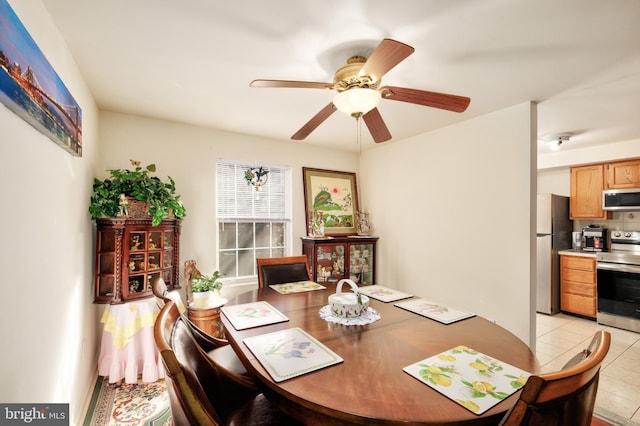 dining space with light tile patterned floors and ceiling fan