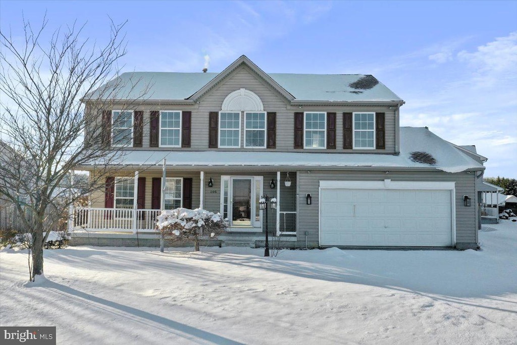 colonial inspired home with a garage and covered porch