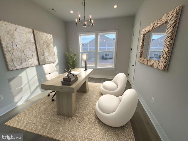 home office with a chandelier and hardwood / wood-style flooring