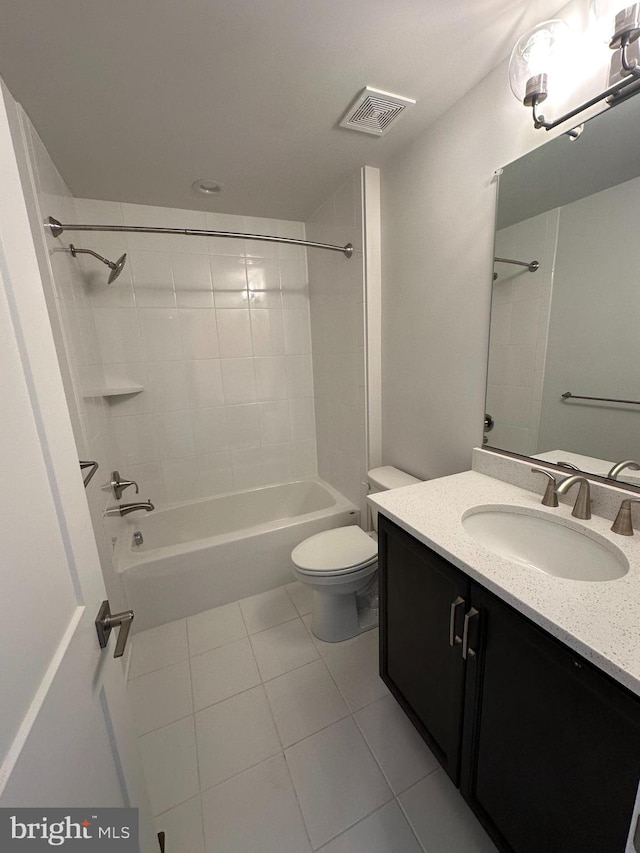 full bathroom featuring tile patterned flooring, tiled shower / bath combo, vanity, and toilet