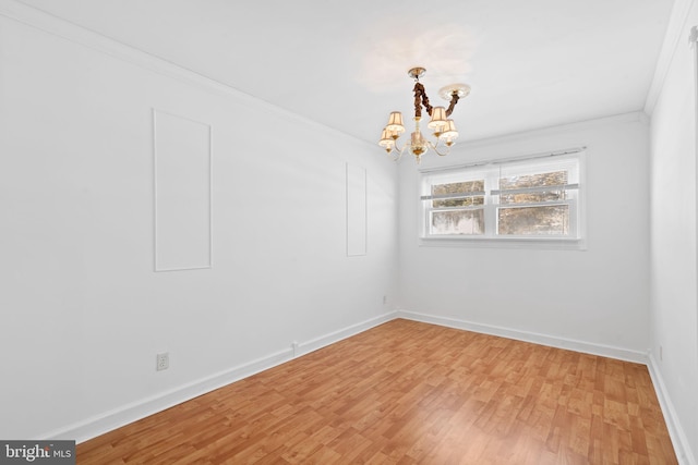 spare room featuring ornamental molding, an inviting chandelier, and hardwood / wood-style flooring