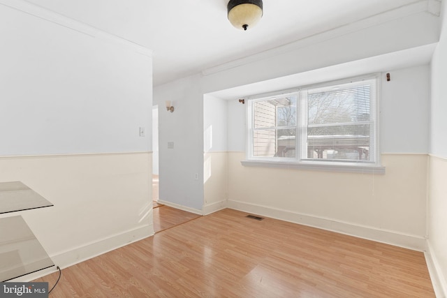 unfurnished room with hardwood / wood-style floors and crown molding