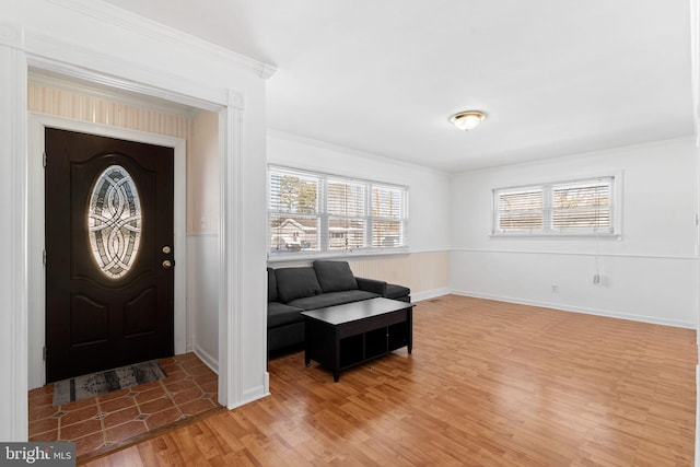 foyer entrance featuring hardwood / wood-style floors and crown molding