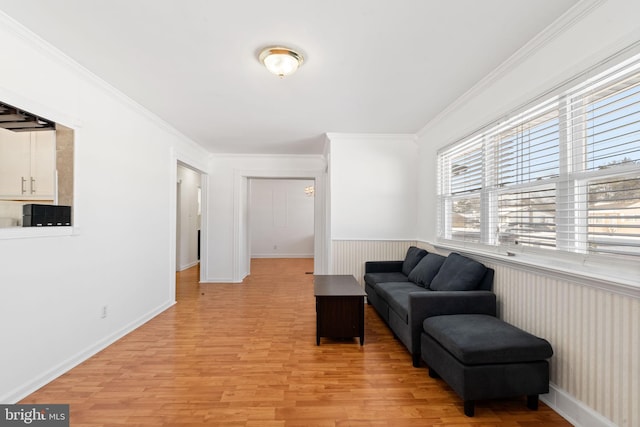 living area featuring ornamental molding and light hardwood / wood-style floors