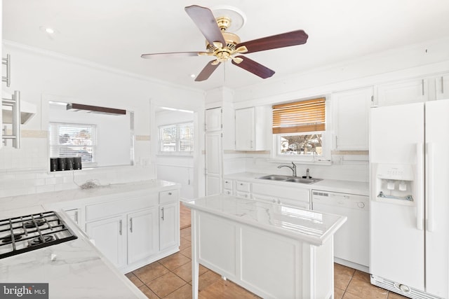 kitchen featuring white appliances, a center island, tasteful backsplash, white cabinets, and sink