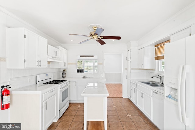 kitchen featuring white appliances, light tile patterned floors, a kitchen island, white cabinetry, and sink