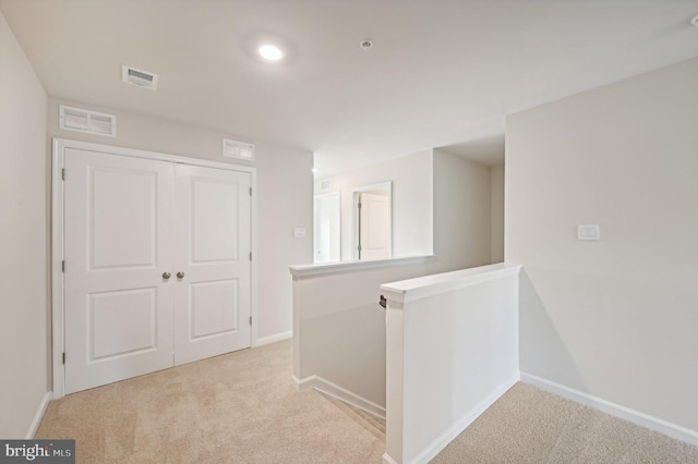 corridor featuring light colored carpet