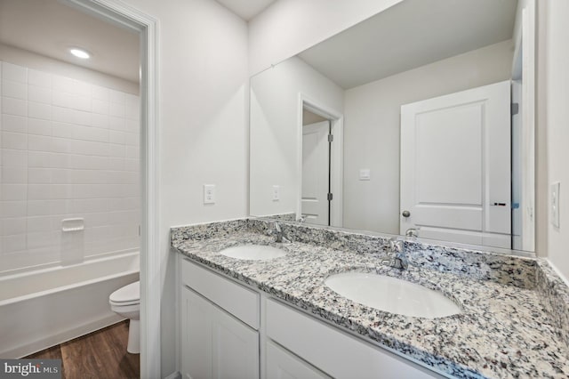 full bathroom featuring toilet, hardwood / wood-style flooring, bathing tub / shower combination, and vanity