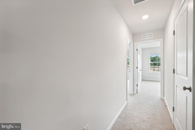 hall with light colored carpet