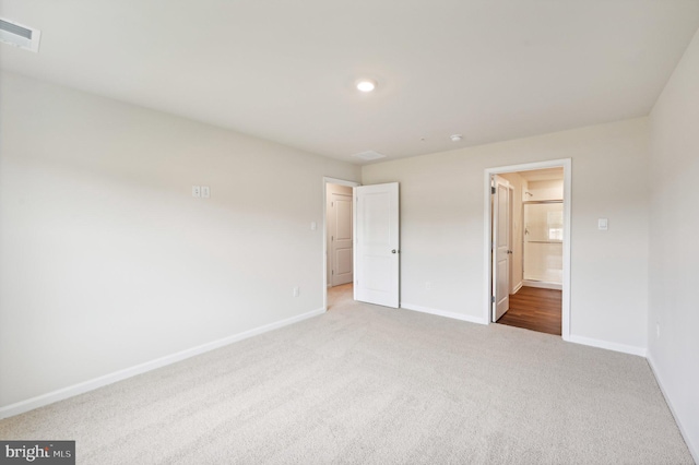 unfurnished bedroom featuring connected bathroom and carpet