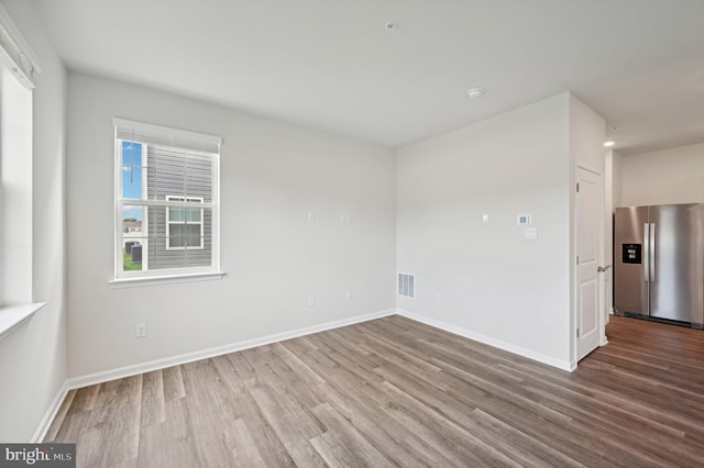 unfurnished room featuring a healthy amount of sunlight and hardwood / wood-style floors