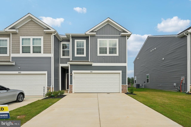 view of front of home with central air condition unit, a front lawn, and a garage