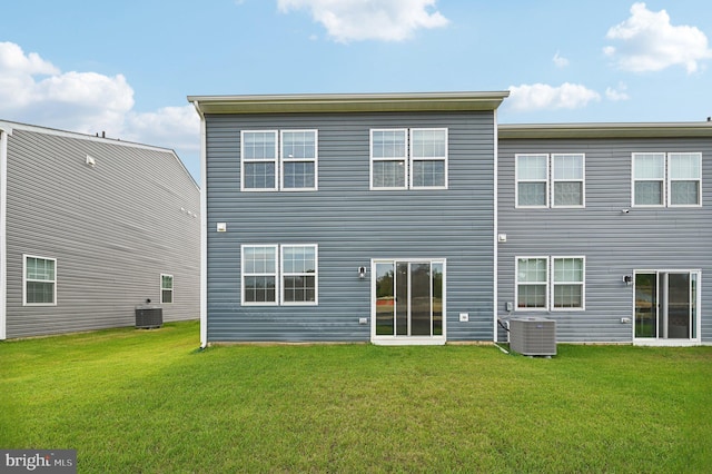 back of property with central AC unit and a yard