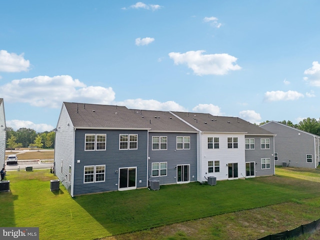 rear view of property featuring central AC unit and a yard