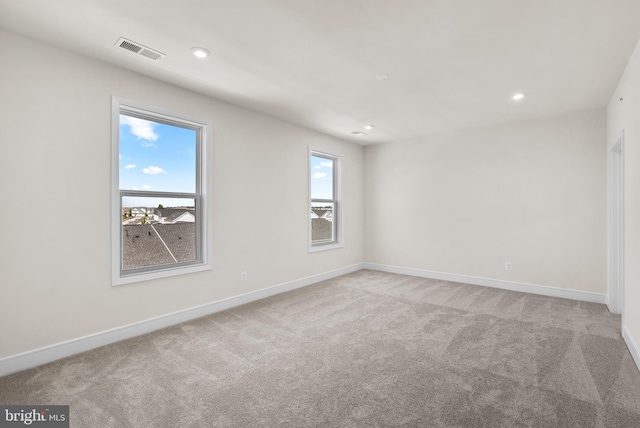 carpeted spare room featuring plenty of natural light