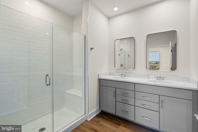 bathroom with vanity, a shower with shower door, and wood-type flooring