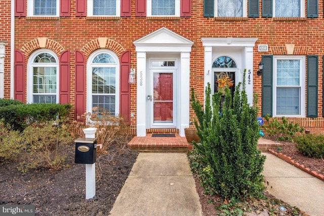 doorway to property featuring brick siding