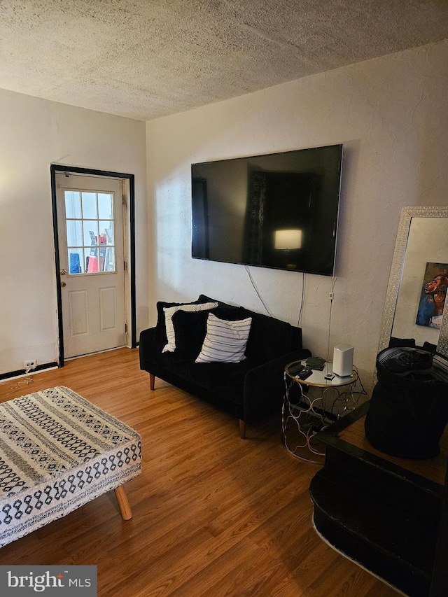 living room with wood-type flooring and a textured ceiling