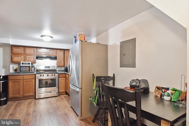 kitchen with electric panel, stainless steel appliances, and wood-type flooring