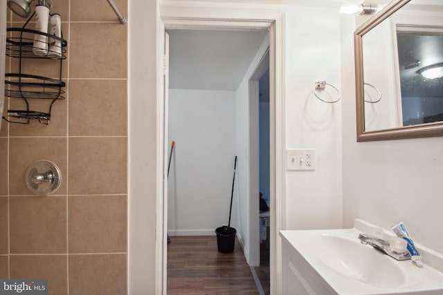 bathroom with a tile shower, wood-type flooring, and vanity