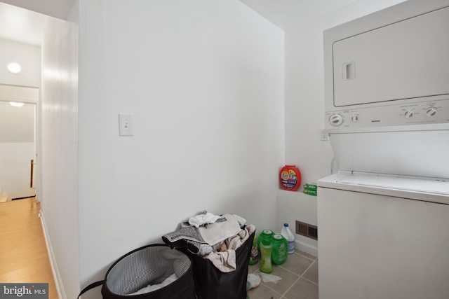 laundry area featuring tile patterned flooring and stacked washer / drying machine