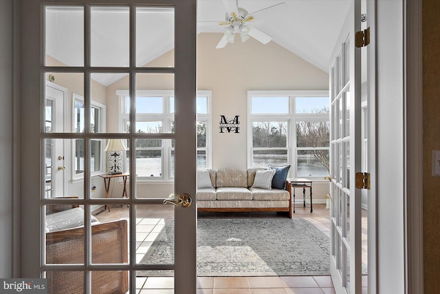 interior space featuring light tile patterned flooring, ceiling fan, french doors, and lofted ceiling