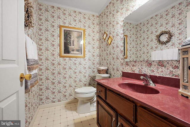 bathroom featuring toilet, vanity, and ornamental molding