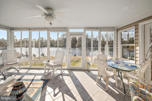 unfurnished sunroom with a water view and ceiling fan