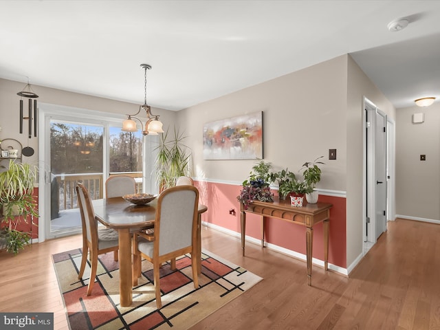 dining space featuring light hardwood / wood-style flooring and a notable chandelier