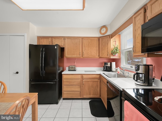 kitchen with black appliances, light tile patterned floors, and sink