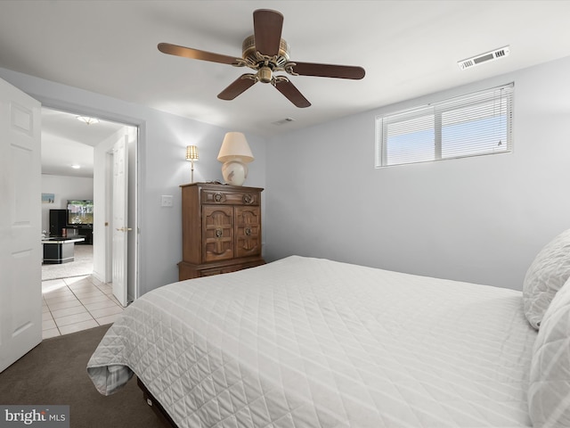 tiled bedroom featuring ceiling fan