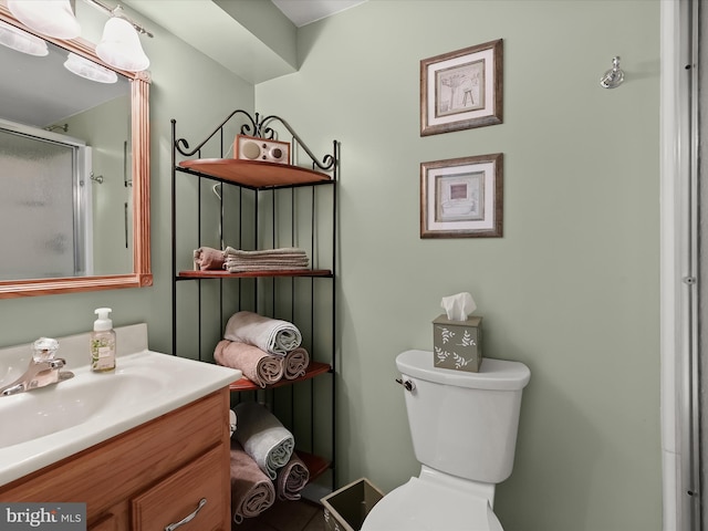 bathroom featuring toilet, an enclosed shower, and vanity